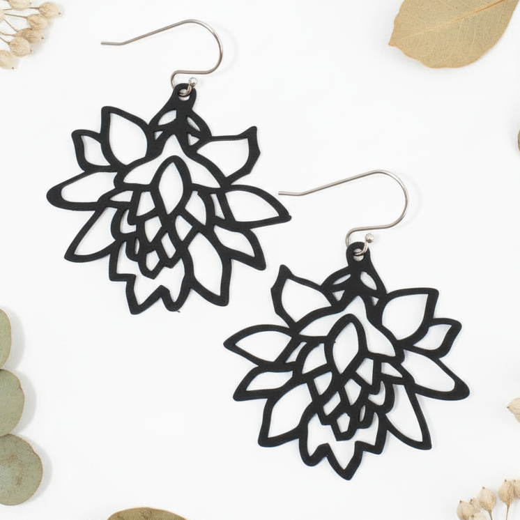 Black flower earrings with earthy natural props